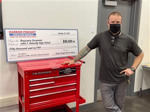 Benjamin Carpenter posing with award check and toolbox