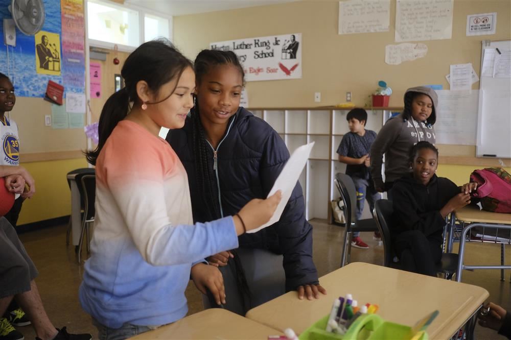  Two WCCUSD Summer School students read their skits to their class.